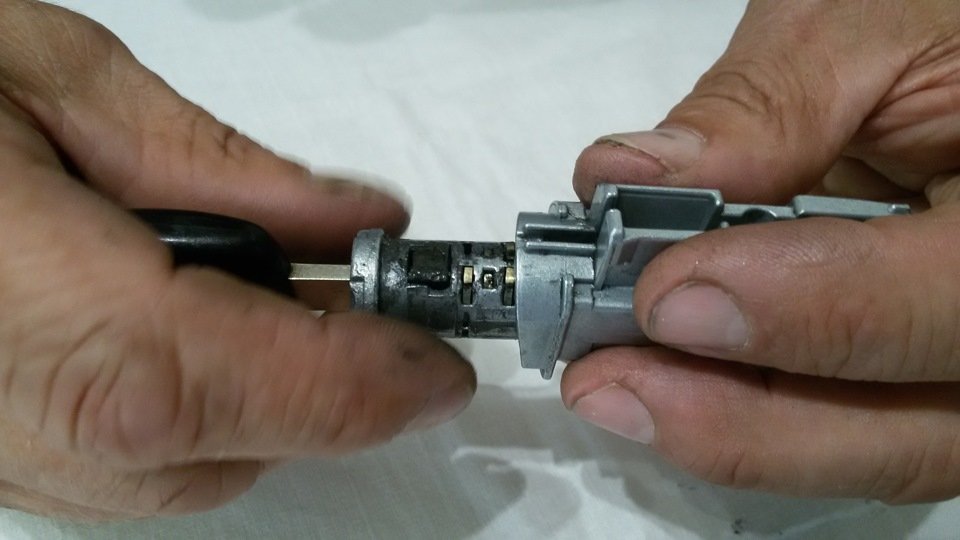 Mobile ignition specialist working with car key and door lock